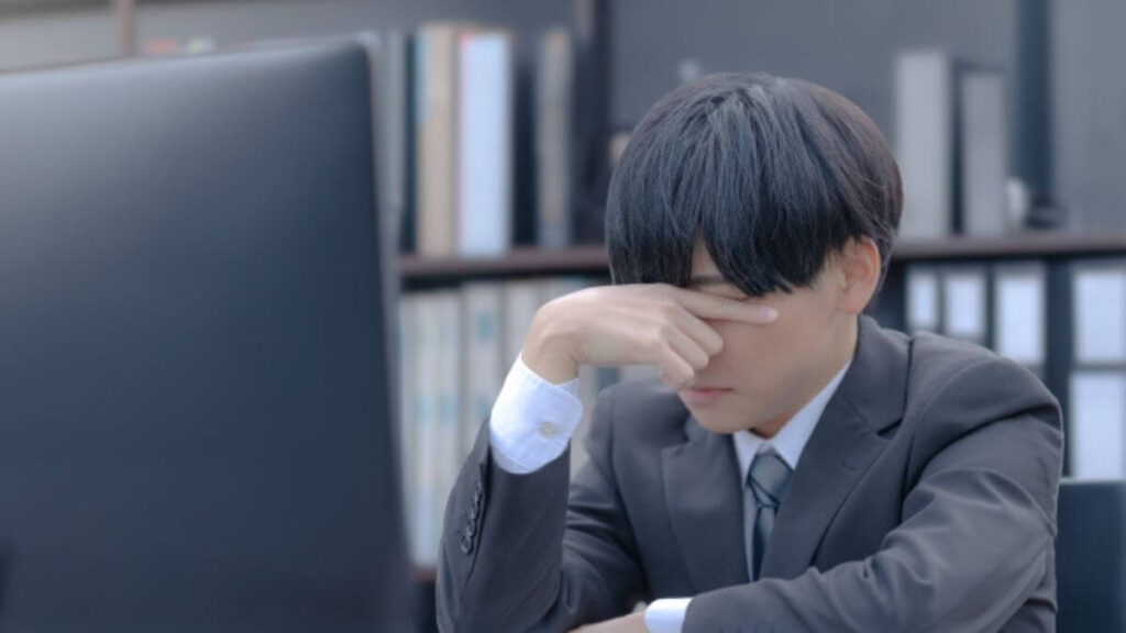 仕事中に体調が悪くなるスーツ姿の男性
