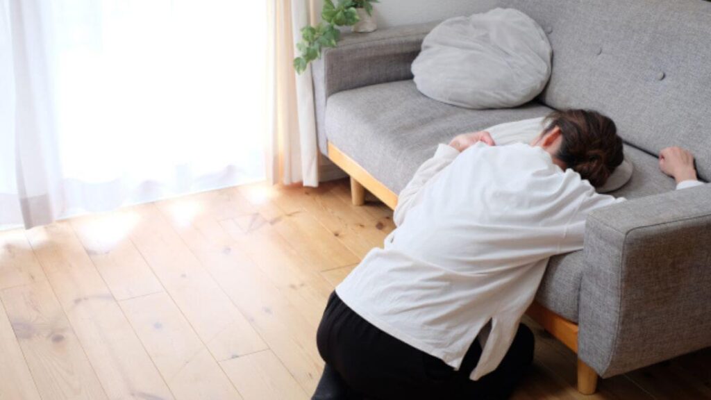 自宅のソファーに頭をつけ体調が悪そうな女性