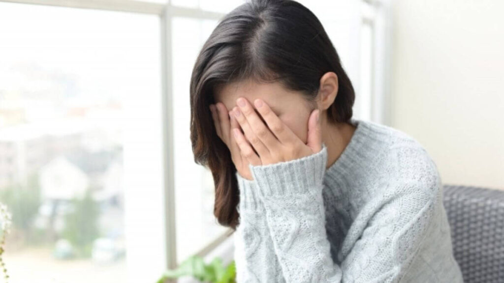 手で顔を多い落ち込む女性
