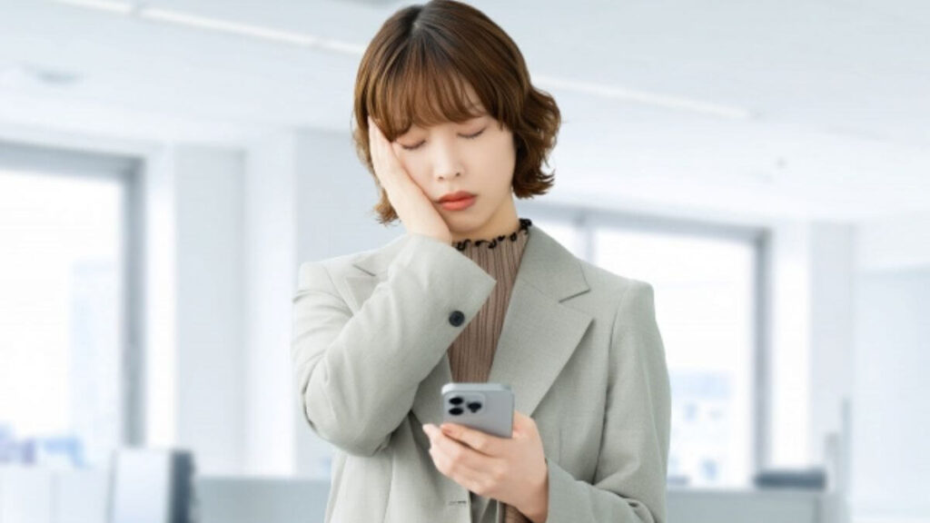 スマホを持ちながら悩む若い女性