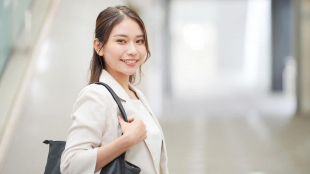 笑顔でバッグを持つスーツ姿の女性