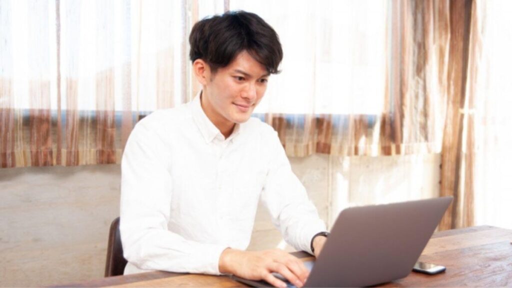 笑顔でパソコンを使う若い男性カウンセラー