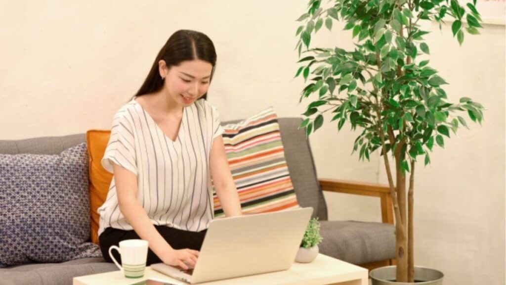 リビングでパソコン作業をする若い女性
