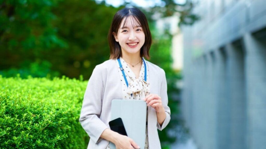 バインダーを持ち笑顔の若いキャリアウーマン