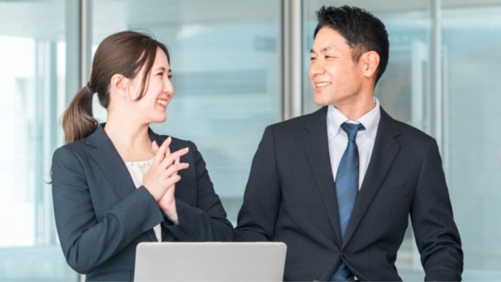 上司の話を笑顔で聞くスーツ姿の女性